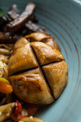 Asian cuisine. Noodles with egg and corn in a plate. On a dark background
