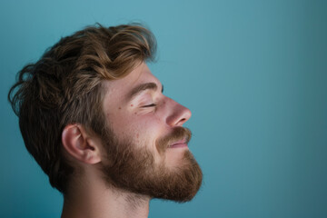 Obraz premium A close up of a man with beard and closed eyes looking to a side