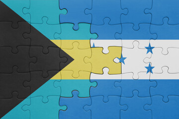 puzzle with the colourful national flag of honduras and flag of bahamas.