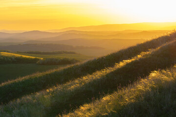 orange sunset over the hills and meadows