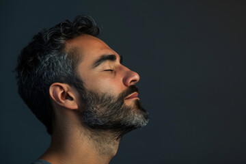 Obraz premium A close up of a man with beard and closed eyes looking to a side