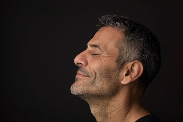 Obraz premium A close up of a man with beard and closed eyes looking to a side