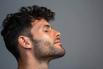 Fototapeta premium A close up of a man with beard and closed eyes looking to a side