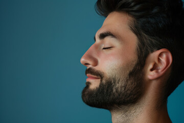 Obraz premium A close up of a man with beard and closed eyes looking to a side