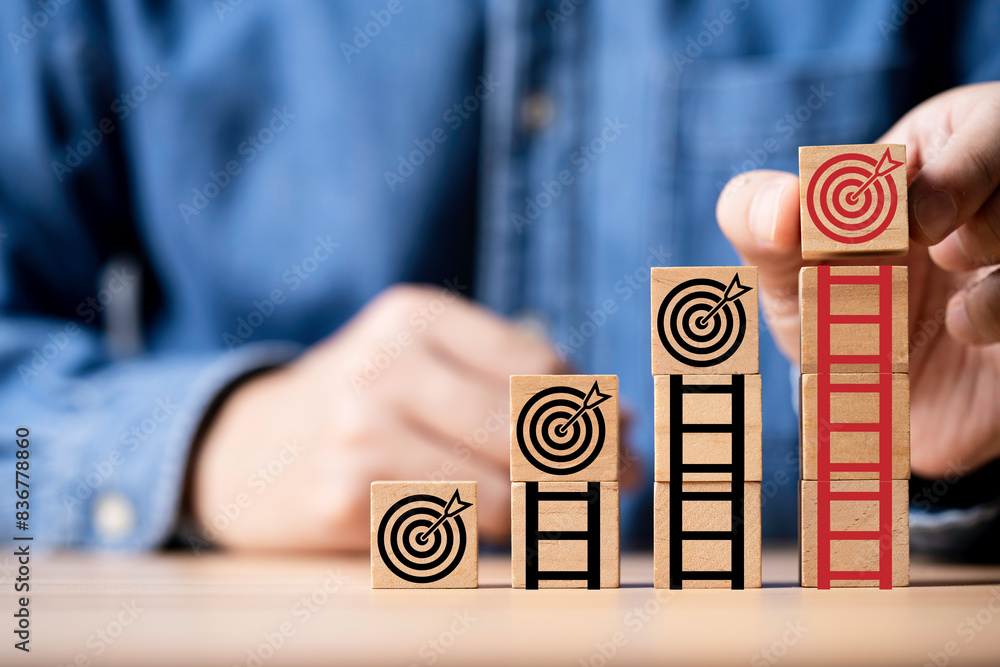 Aufkleber businessman putting dartboard with arrow on the top of ladder for enhance and achievement setup busi