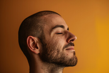 Obraz premium A close up of a man with beard and closed eyes looking to a side
