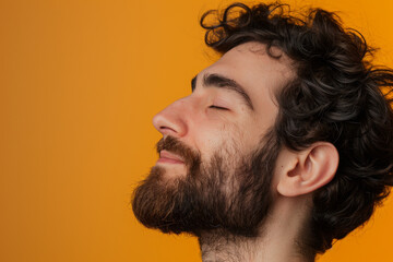 Obraz premium A close up of a man with beard and closed eyes looking to a side