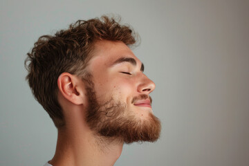Obraz premium A close up of a man with beard and closed eyes looking to a side