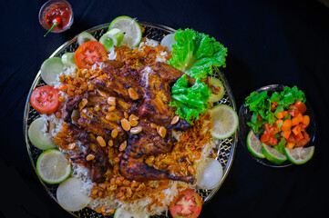 kabsa, rice, a typical Arabic dish, with grilled chicken and fresh vegetables
