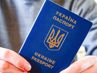 Hand holding a Ukrainian passport, suggesting anticipation for adventure.