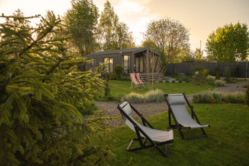Barnhouse, Barn house. Wooden secluded house in the Scandinavian and Finland modern style with beautiful green garden with sun loungers for relaxation.