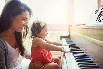 Mom, toddler and happy for learning by piano with help, care or bonding for love in family home. Girl, mother and daughter by keyboard for music, teaching or playing for development with art in house