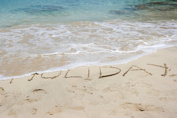 concept of a holiday cancellation or end of the holiday by washing away the word holiday by the sea 
