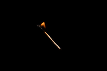 Lit falling match on a black background.