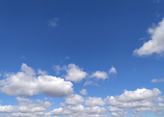 Fototapeta premium Clear blue sky texture and white fluffy cloud nature background. The sun shines bright in the daytime in summer
