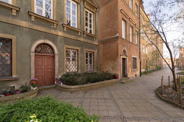 Charming historic building facade featuring an arched doorway and barred windows. The cobblestone...