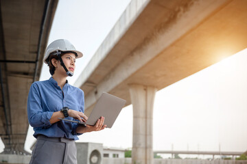 An Asian woman architect working at a highway construction site Female civil engineers monitor...