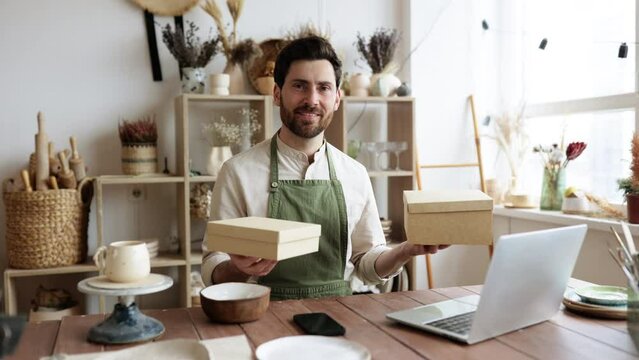 Male online store preparing an order for shipping in a warehouse. E-commerce entrepreneurship. Small business owner packing his handmade product into cardboard box.