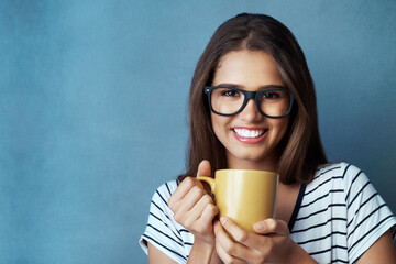 Happy woman, portrait and glasses with coffee for morning beverage, caffeine or drink on a blue...
