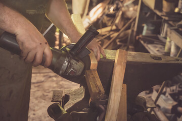 Carpenter cuts wooden blocks with a circular saw in an outdoor workshop. Close-up