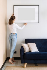 Woman decorated cozy home with art work in picture frame