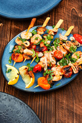 Seafood kebabs on wooden background, shellfish.