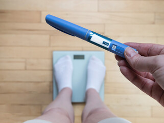  Ozempic Insulin injection pen for diabetics and weight loss. Woman weighs herself and holds...