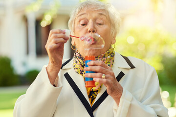 Bubbles, fun and elderly woman in garden for memories, entertainment and good mood in backyard....
