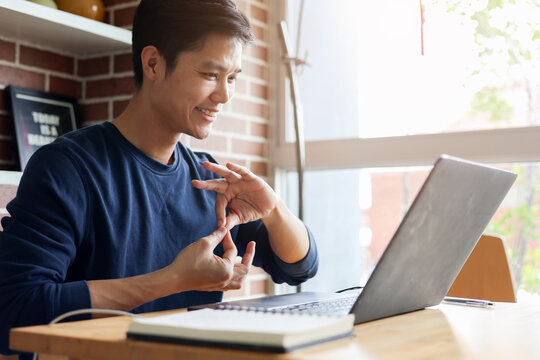 close up asian employee make gesture hand about help sign language to meeting and talking with team from webinar in home for office culture lifestyle concept