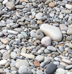 Pebbles on the seashore as an abstract background. Texture