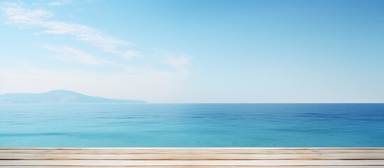 Fototapeta premium White wooden table with a serene background of blurred blue sky and sea, perfect as a copy space image for product displays or ads.