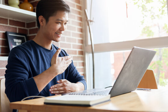close up asian employee make gesture hand about help sign language to meeting and talking with team from webinar in home for office culture lifestyle concept
