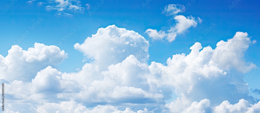Poster background of blue sky with fluffy white clouds providing copy space image.