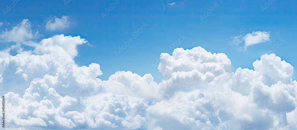 Poster background of white clouds in a clear blue sky with ample copy space image.