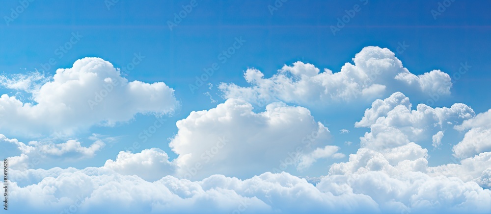 Aufkleber the fluffy clouds drift in the clear blue sky, creating a serene and picturesque scene for a copy sp