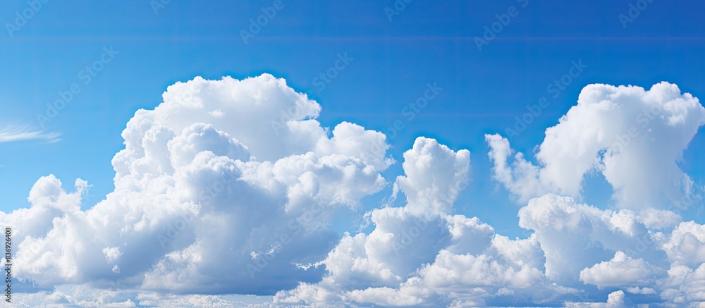 Poster Scenic view of a clear blue sky complemented by fluffy white clouds in a copy space image.