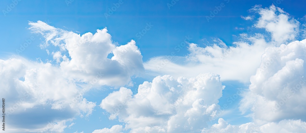 Aufkleber Blue sky with fluffy white clouds on a sunny day, creating a serene atmosphere for a copy space image.