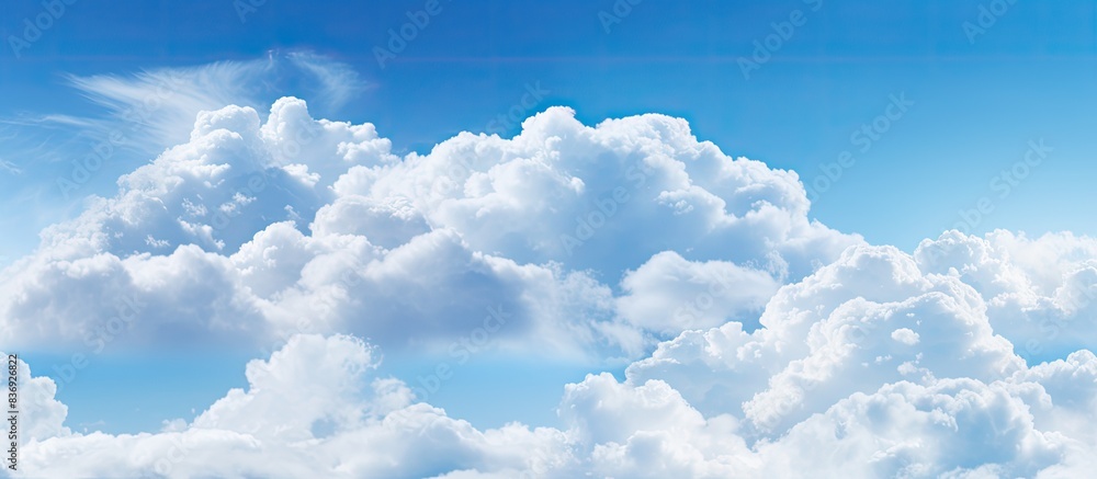 Poster Fluffy white clouds against a clear blue sky, creating a soothing backdrop with copy space image.