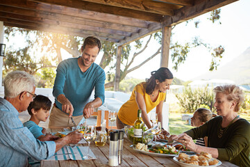 Big family, eating and lunch with food outdoor on patio with conversation, bonding or healthy meal in summer. Parents, grandparents and kids at dining table in home backyard for love, talk or dinner