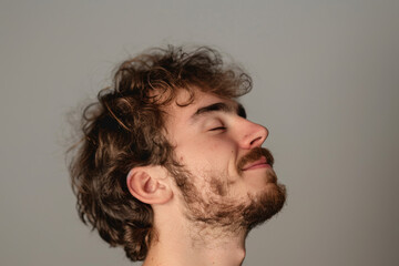 Obraz premium A close up of a man with beard and closed eyes looking to a side