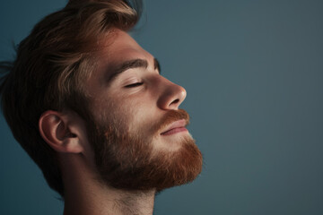 Fototapeta premium A close up of a man with beard and closed eyes looking to a side