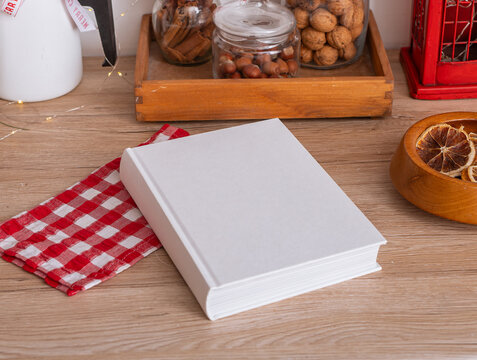 Book mockup in kitchen, cook table with recipe background. Top view cookbook food cover. Empty above white mock set frame. Poster interior clean utensils business concept.