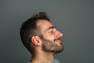 Obraz premium A close up of a man with beard and closed eyes looking to a side