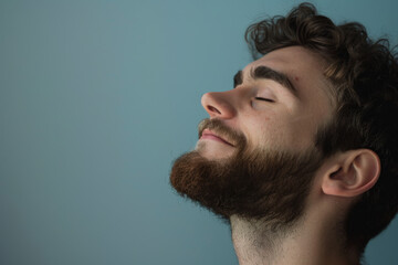 Obraz premium A close up of a man with beard and closed eyes looking to a side