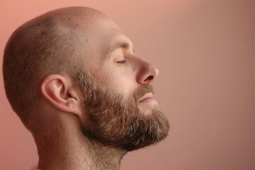 Obraz premium A close up of a man with beard and closed eyes looking to a side