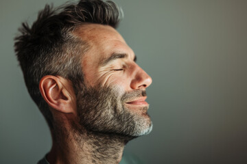 Obraz premium A close up of a man with beard and closed eyes looking to a side