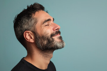 Obraz premium A close up of a man with beard and closed eyes looking to a side