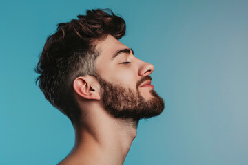 Fototapeta premium A close up of a man with beard and closed eyes looking to a side