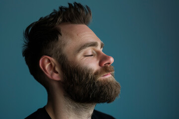 Obraz premium A close up of a man with beard and closed eyes looking to a side