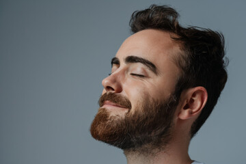 Obraz premium A close up of a man with beard and closed eyes looking to a side